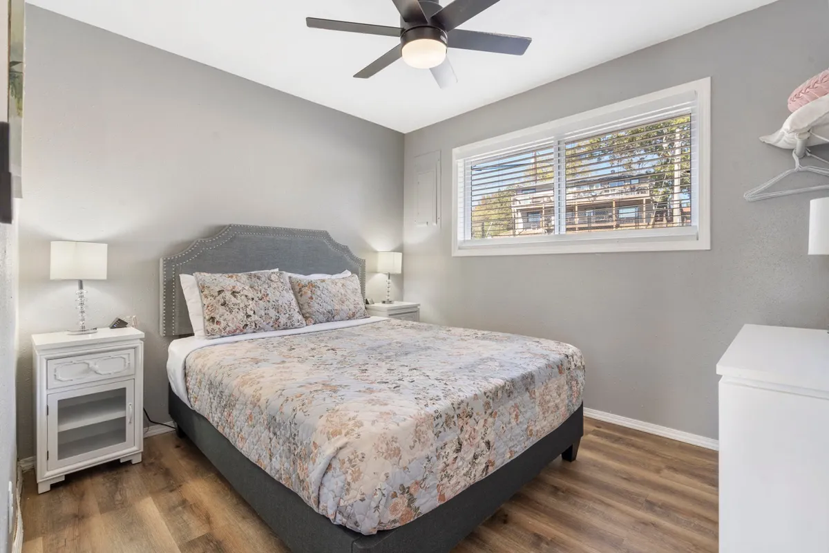 A serene bedroom with a neatly made bed, bedside tables, and a window that fills the room with natural light. The setting highlights a peaceful environment that invites relaxation and restful sleep.