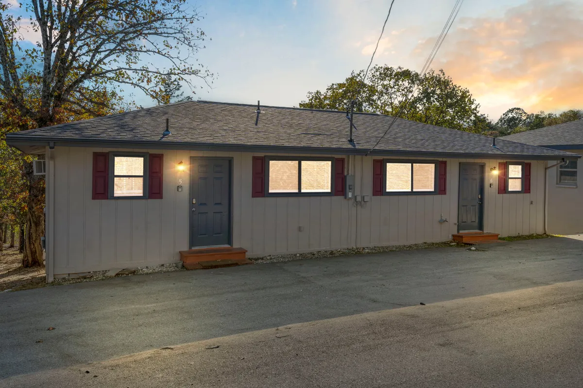 The resort’s charming exterior is showcased with front doors and windows framed by attractive landscaping. The inviting porch area hints at the comfort and community awaiting inside, while the outdoor setting encourages families to gather, relax, and explore.